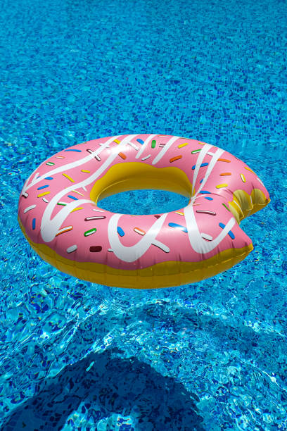 istock pink inflatable donut doughnut floating mattress in swimming pool. Beach pool accessories. Summer holiday concept 1274094196