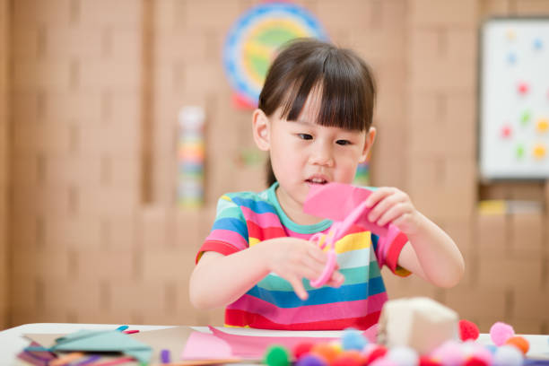 istock young girl using scissors cutting paper for making craft for home schooling 1274101013