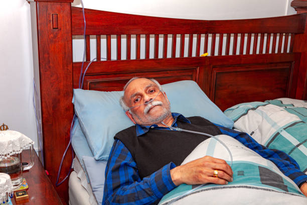 72-летний индийский мужчина видел восстановления в своей постели у себя дома после его лапараскопический желчный пузырь хирургии смотрит п� - medical oxygen equipment healthcare and medicine 70s mature adult стоковые фото и изображения