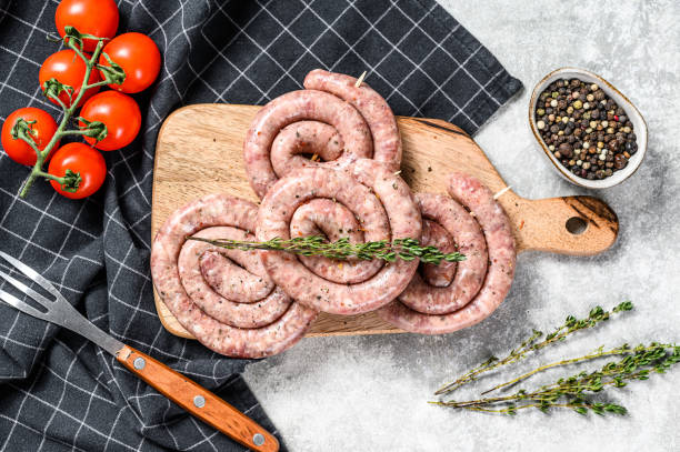istock Fresh raw spiral chicken sausages. Gray background. Top view 1274112492