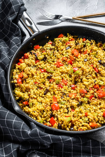 istock Cooked bulgur with vegetables in a pan. Gray background. Top view 1274114203