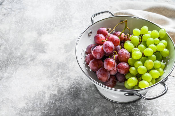 istock A branch of red and green grapes in a colander. Gray background. Top view. Copy space 1274123740
