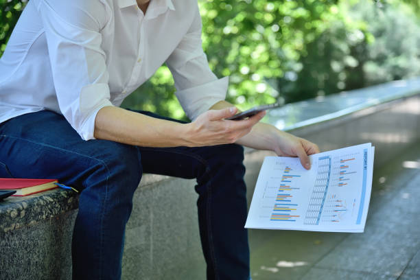 istock Trader sitting in park and using smartphone. 1274143730