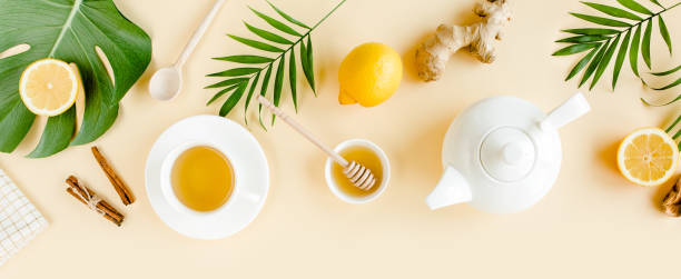 istock Herbal tea with mint, ginger, lemon, honey and other herbs on yellow background. Flat lay, top view 1274172902
