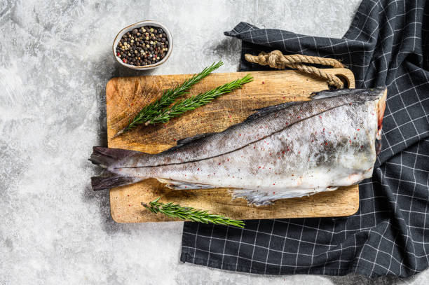 istock Raw haddock fish on the cutting Board. Gray background. Top view 1274173182