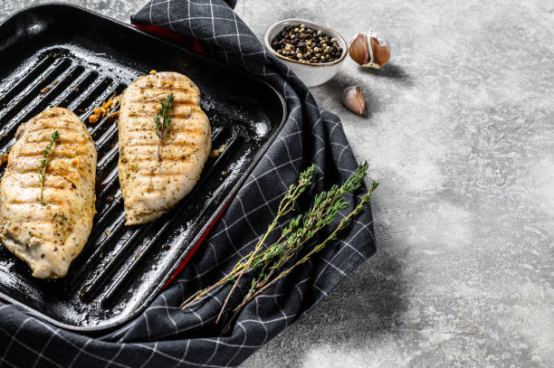 istock grilled chicken breast in a pan with thyme and garlic. gray background. Top view. Copy space 1274173451