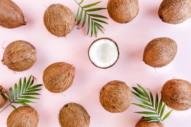 istock Pattern, texture with coconuts and tropical palm leaves on pink background. Tropical abstract background. Flat lay, top view 1274205133