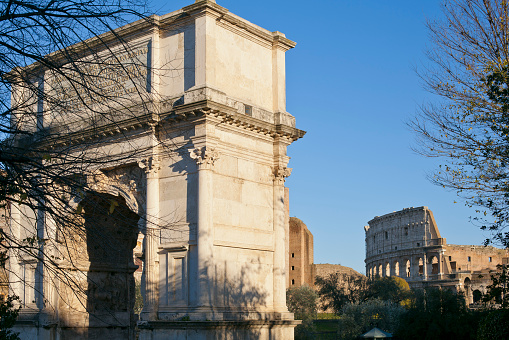 Roma, Italy - 29th december 2014: Arch of Titus in the Roman Forum and the Coliseum in the background.