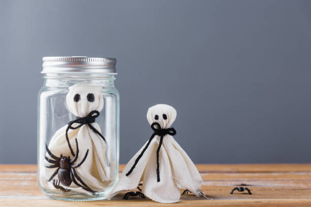 istock closeup white ghost and spider in jar on wooden 1274220475
