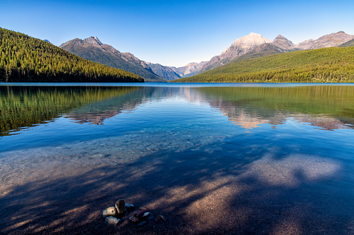 The reflection of the mountain range off Bowman Lake in Glacier National Park, Montana.