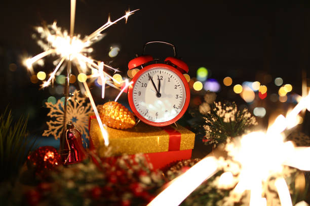 istock Red alarm clock with christmas gifts against night 1274277182
