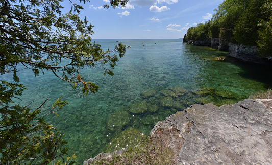 Crystal clear waters of the Lake Michigan at Whitefish Dunes State Park, Sturgeon Bay, Wisconsin. Few kayakers enjoy sunny weather.