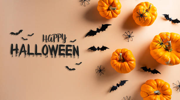 istock Halloween decorations made from pumpkin, paper bats and black spider on pastel orange background. Flat lay, top view with copy space for text. 1274315748