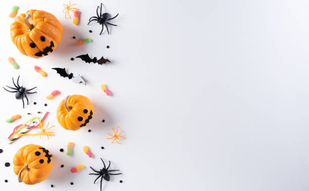 istock Halloween decorations made from pumpkin, paper bats and black spider on white background. Flat lay, top view with copy space for text. 1274315808