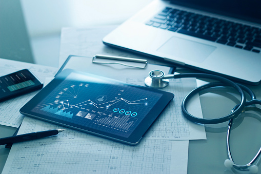 Concepto de negocio de atención médica, examen médico y datos gráficos de crecimiento de negocios en tableta con el portapapeles del informe de salud del médico sobre el fondo. photo