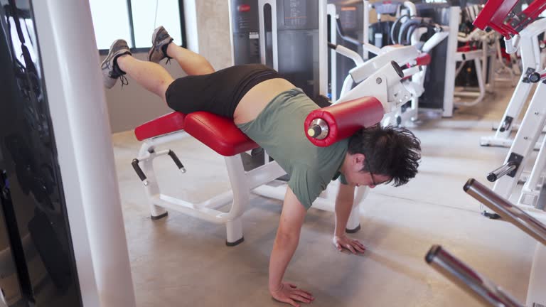 4K Man doing Push-up in leg exercise machine at the gym. Funny comedy concept