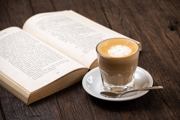 istock Coffee cup cappuccino hot latte or coffee with milk in a glass cup, open book 1274528207