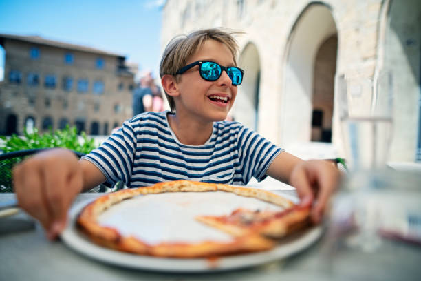 istock Little boy enjoying pizza at an Italian restaurant 1274604552