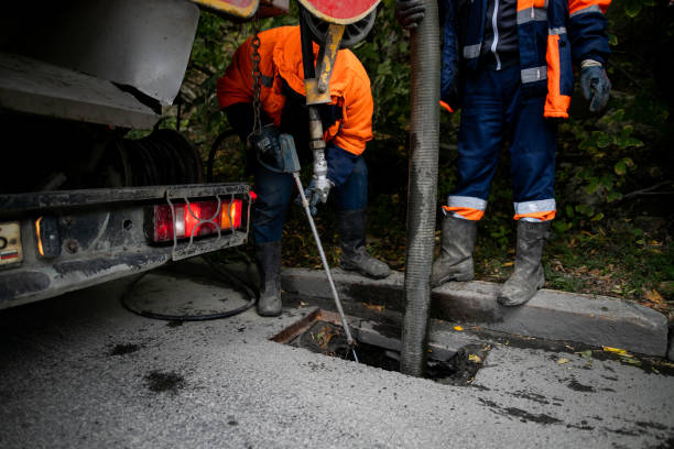Cleaning storm drains from debris, clogged drainage systems are cleaned with a pump and water stock photo