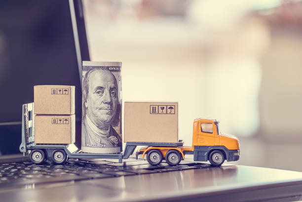 istock US USD 100 dollar bills, boxes, a trailer truck on a laptop 1274647864