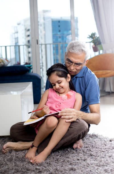 istock Grandfather help her granddaughter to do homework 1274647895