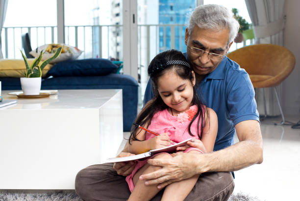 istock Grandfather help her granddaughter to do homework 1274648430