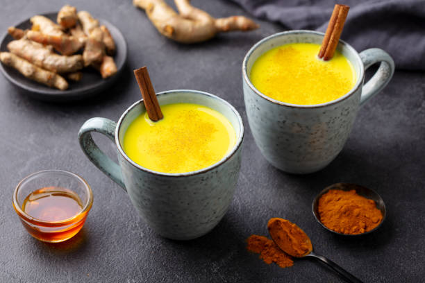 istock Turmeric drink, latte, tea, milk with cinnamon in a mug with fresh and powder turmeric. Grey background. Close up. 1274679699