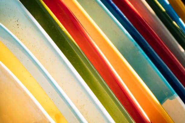 istock Close up Set of different color surf boards in a stack on sandy beach for rent. Multicolored surfboards as rainbow. 1274681423