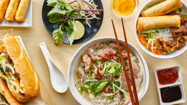 assorted vietnamese dishes with pho, bahn mi, spring rolls in top down composition assorted vietnamese dishes with pho, bahn mi, spring rolls in top down composition on dinner table hoisin sauce stock pictures, royalty-free photos & images