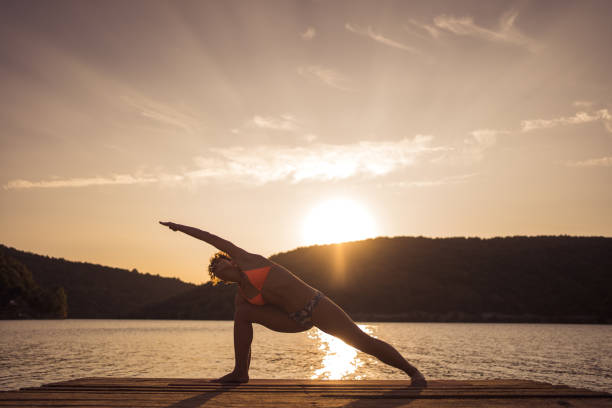 istock Woman practicing yoga on lake 1274690651