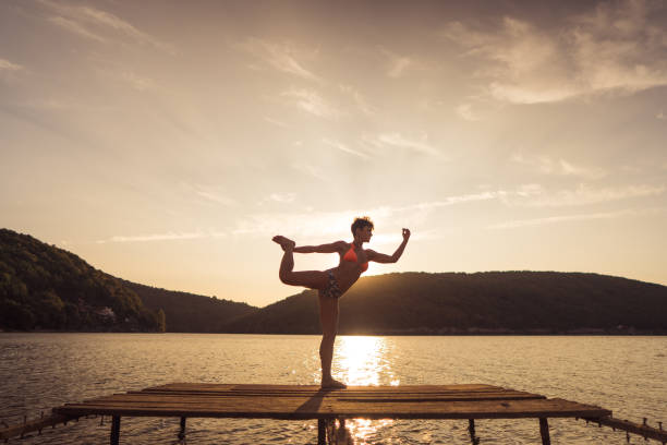 istock Woman stretching on the lake 1274695135