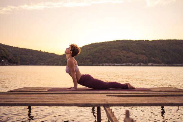 istock Woman practicing yoga on lake 1274695973