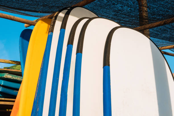 istock Close up stack of blue color soft surfboards in a stack by ocean.Bali.Indonesia. Surf boards on sandy beach for rent. Surf lessons on Weligama beach, Sri Lanka. 1274699046