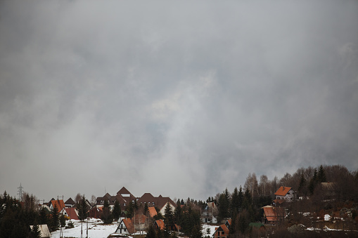 Wide shot of foggy and cloudy landscape of a village on top of Kopaonik mountain.