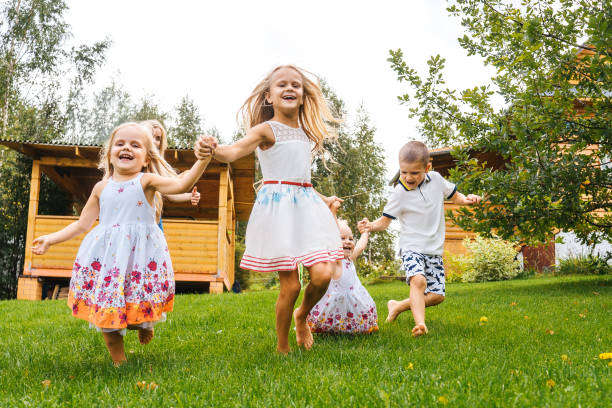 istock Happy kids running in garden on grass. 1274714856