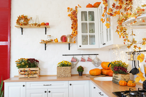 Autumn kitchen interior with pumpkin, fallen leaves, Thanksgiving dinner preparation