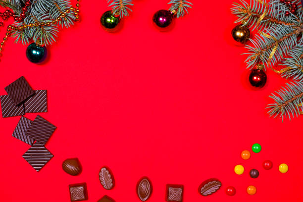 istock Chocolate and candy on a red background with a spruce sprig for Christmas. 1274727796