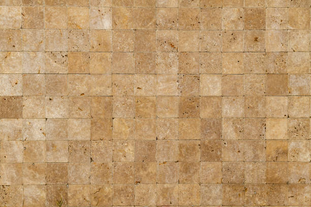 Wall background with Yellow natural sandstone tiles stitched together with clay stock photo