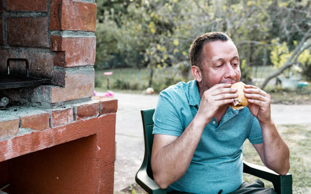 istock A man enjoying a burger in the yard 1274753245