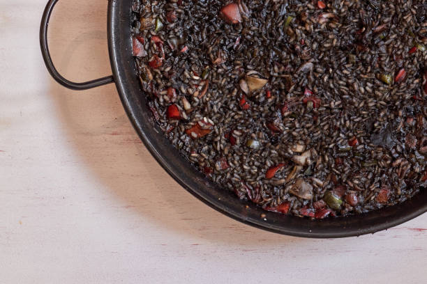 istock Typical black Spanish rice. Traditional paella made with rice and squid ink 1274755864