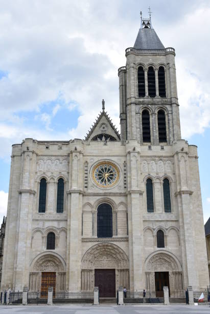 Basilique Royale de Saint-Denis or Basilica of Saint Denis, west facade. Paris, France. Paris, France. View of the Basilique Saint-Denis, the first gothic church. West Facade and bell tower with blue sky and clouds. basilica stock pictures, royalty-free photos & images