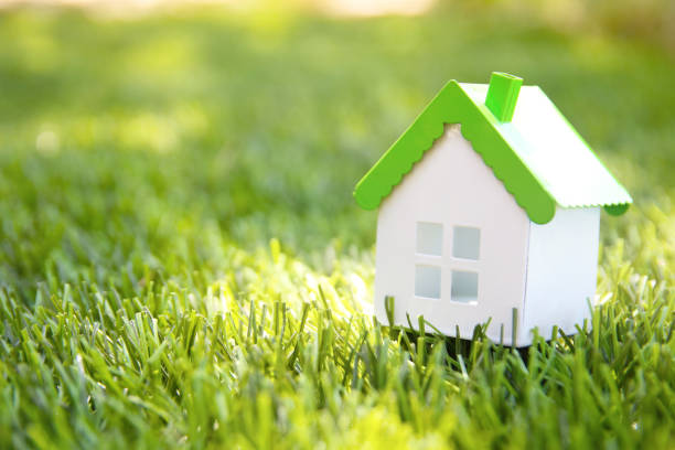 istock Model House  on green grass with sunlight background 1274777837