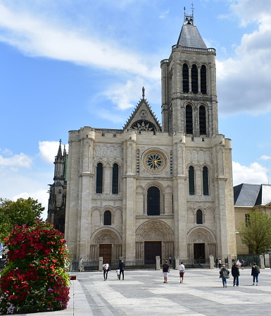 Paris, France. August 12, 2019. View of the Basilique Saint-Denis, the first gothic church. West Facade and bell tower with blue sky and clouds.