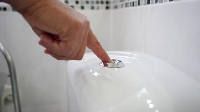 Senior man flushing the toilet