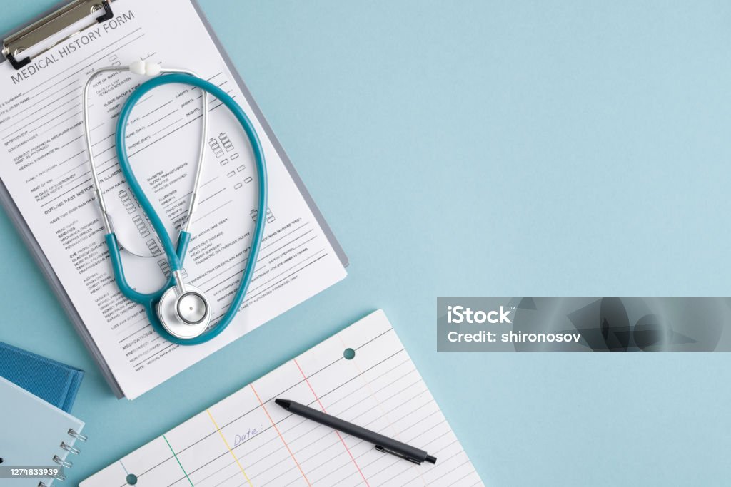 Top view of medical history form in clipboard, stethoscope and other stuff Top view of medical history form in clipboard, folded stethoscope, notebooks and pen on blank card with copyspace on the right Medical Chart Stock Photo