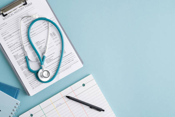Top view of medical history form in clipboard, stethoscope and other stuff Top view of medical history form in clipboard, folded stethoscope, notebooks and pen on blank card with copyspace on the right exam paper stock pictures, royalty-free photos & images