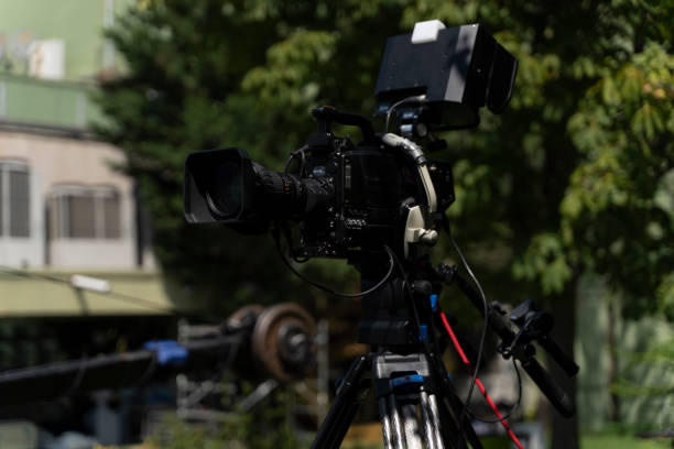 istock Video camera - Ready for recording show in outdoor TV studio - focus on camera aperture 1274836601