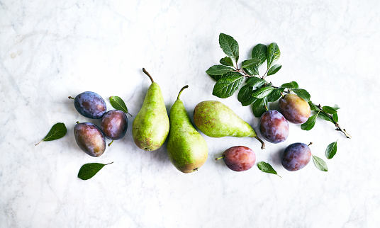 Autumn Fruits. Plums and pears on gray marble background. Flat lay
