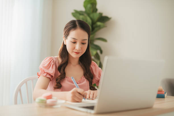 istock woman use phone and computer work at home 1274839058