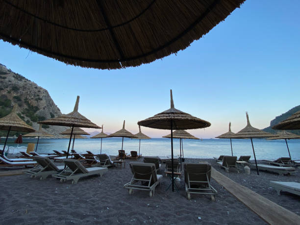 istock Sun beds and umbrellas on beautiful bay. 1274840876